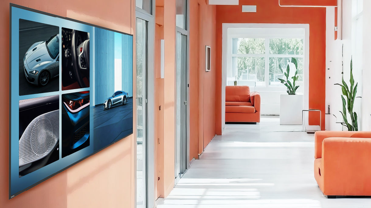 A vibrant BenQ digital signage display showing a grid of car and architectural images in a bright orange hallway, illustrating how 800 nits of brightness ensures optimal visibility for impactful workplace solutions.