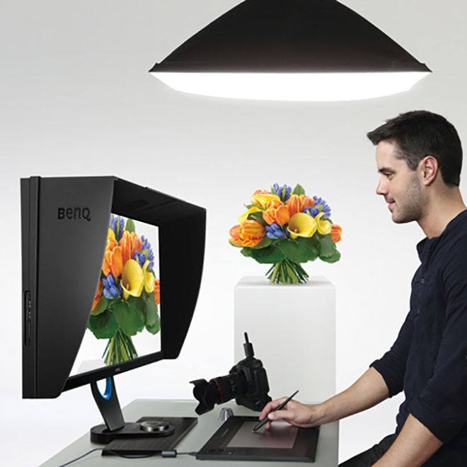 A man standing in front of the monitor with shading hood