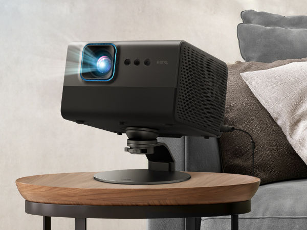 BenQ projector on adjustable stand angled for movie watching in a cozy living room