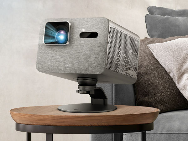 BenQ projector on adjustable stand angled for movie watching in a cozy living room