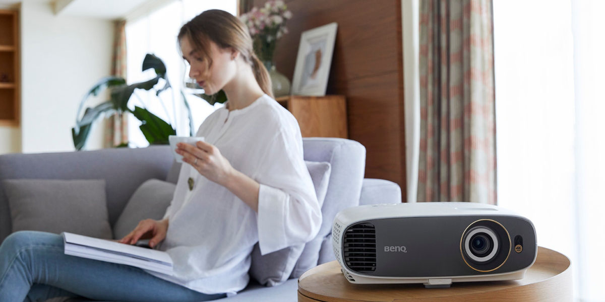 A woman stays at home working while enjoying her free time with a projector for visual entertainment