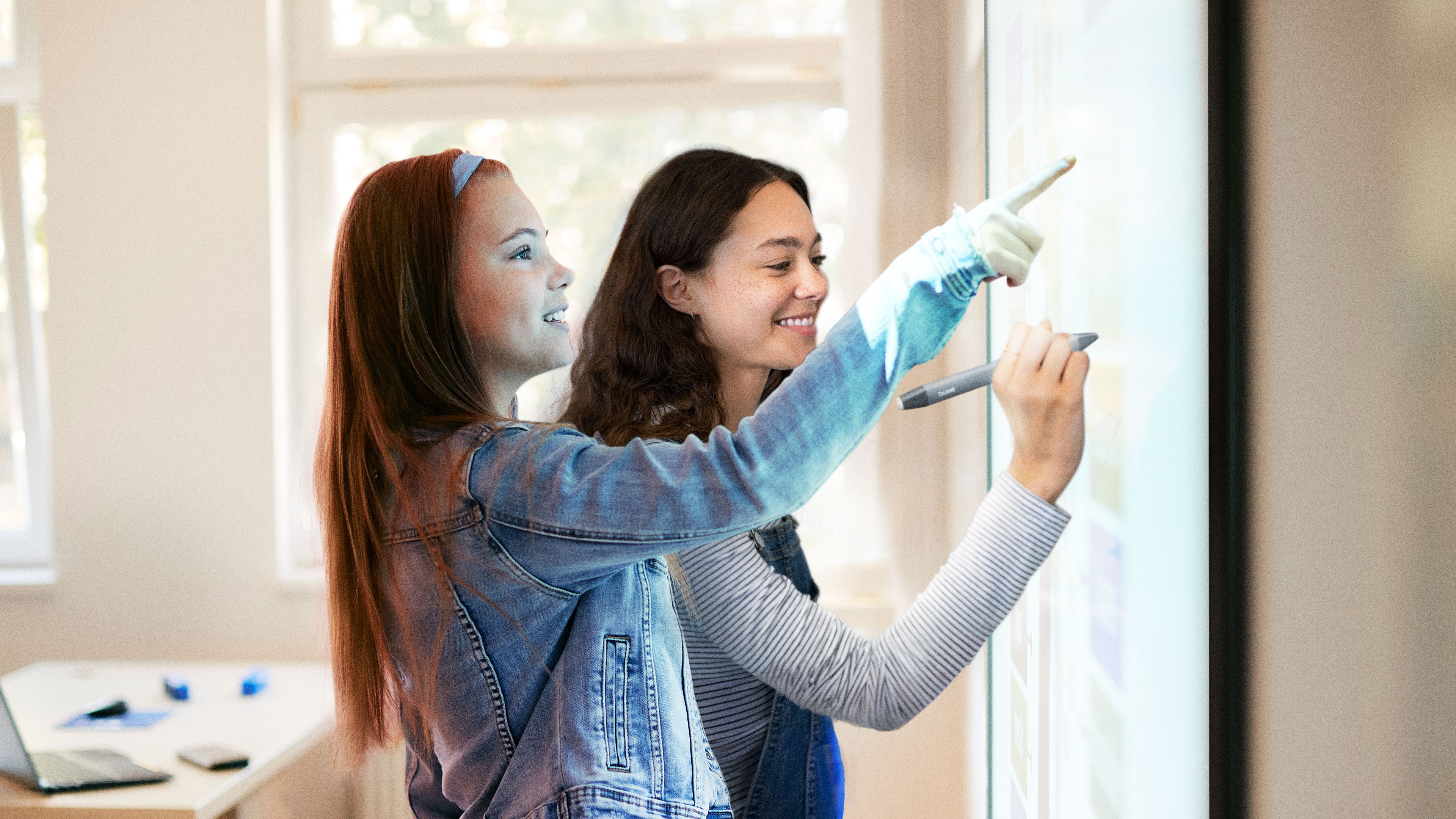 Two young students interacting and writing on the RP03 BenQ Board interactive display