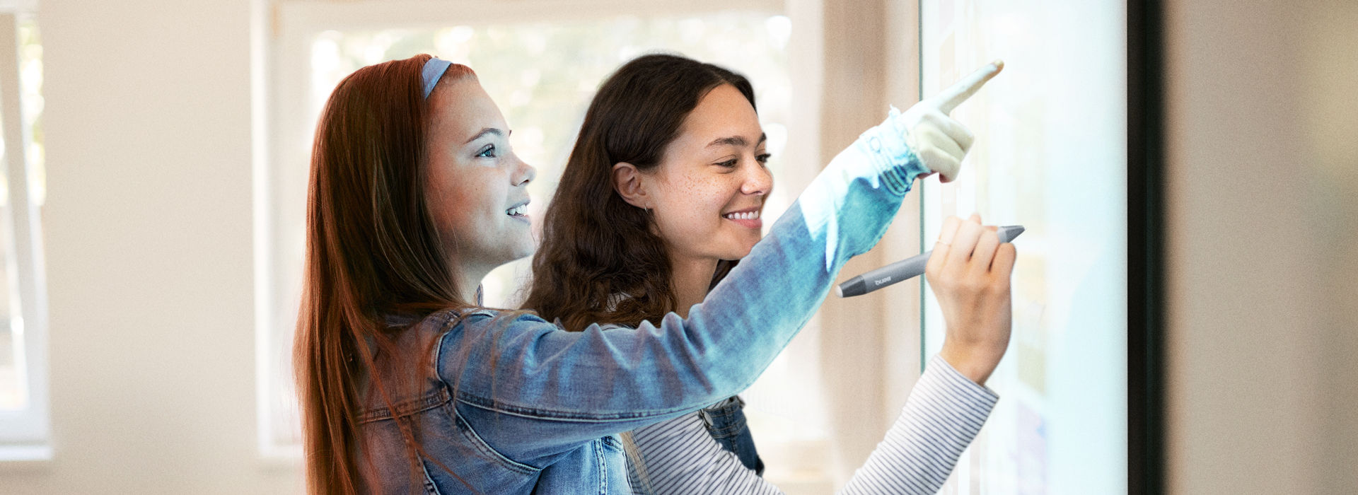 Two young students interacting and writing on the RP03 BenQ Board interactive display