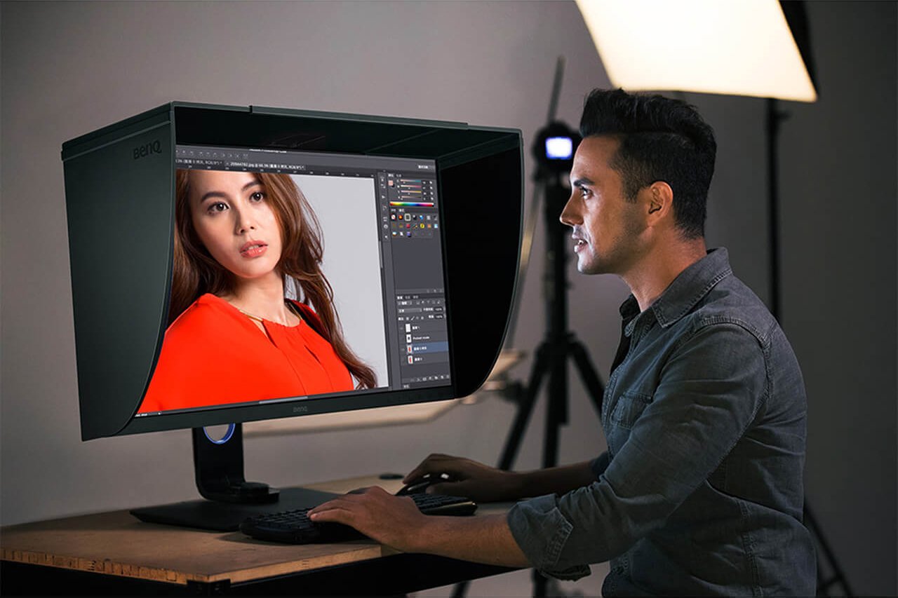 The photographer is editing photo with monitor that comes with a shading hood to prevent the image displayed on the monitor form scattered ambient light.