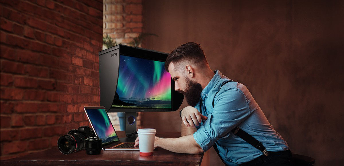 The photographer is examining, editing and communicating his work via onscreen images.