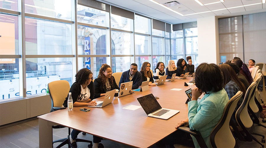 There a group of team members sharing their ideas and opinions with their own devices in the meeting room.