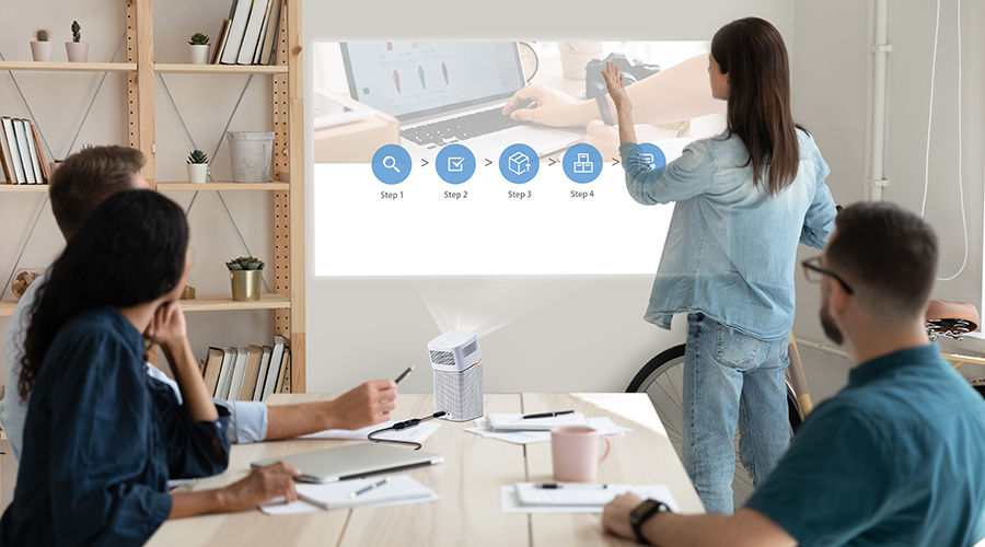 A group of people preparing for impromptu meeting using portable projector 