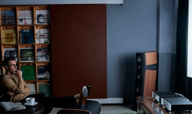 A guy sitting on the chair watching big screen movie on a home projector