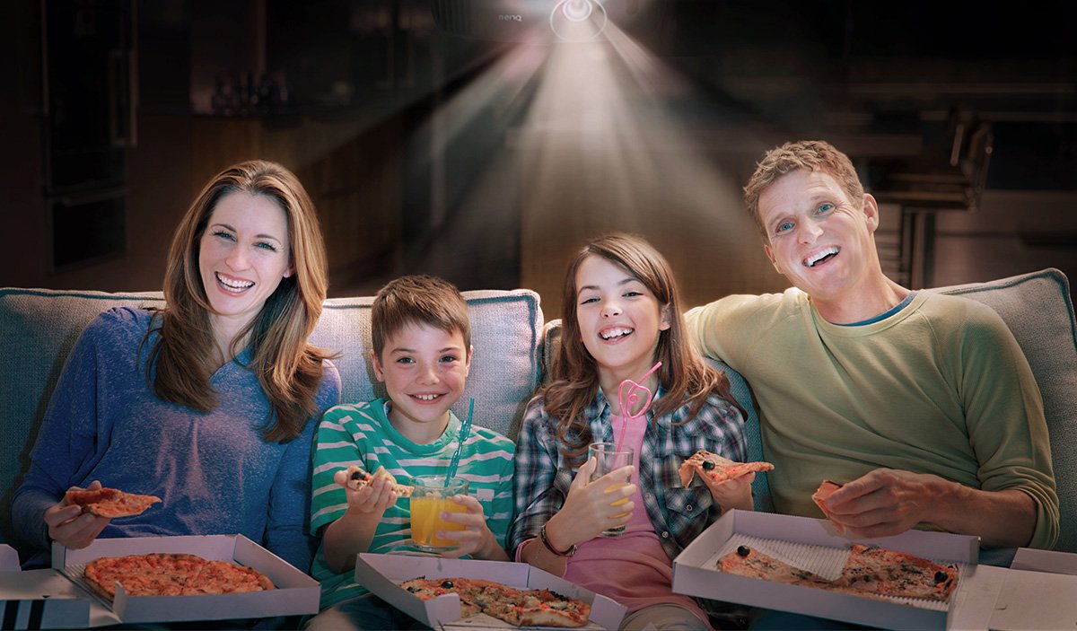 The family is having pizzas and enjoying the movie projected by high quality projector that comes with the most beautiful and realistic colors.