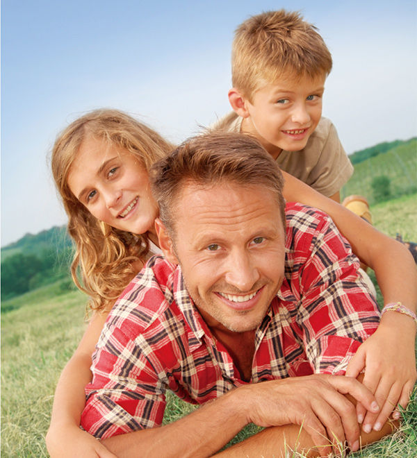  BenQ DLP Rec.709 projectors projects the scene of a father lying on the grassland with his daughter and son.