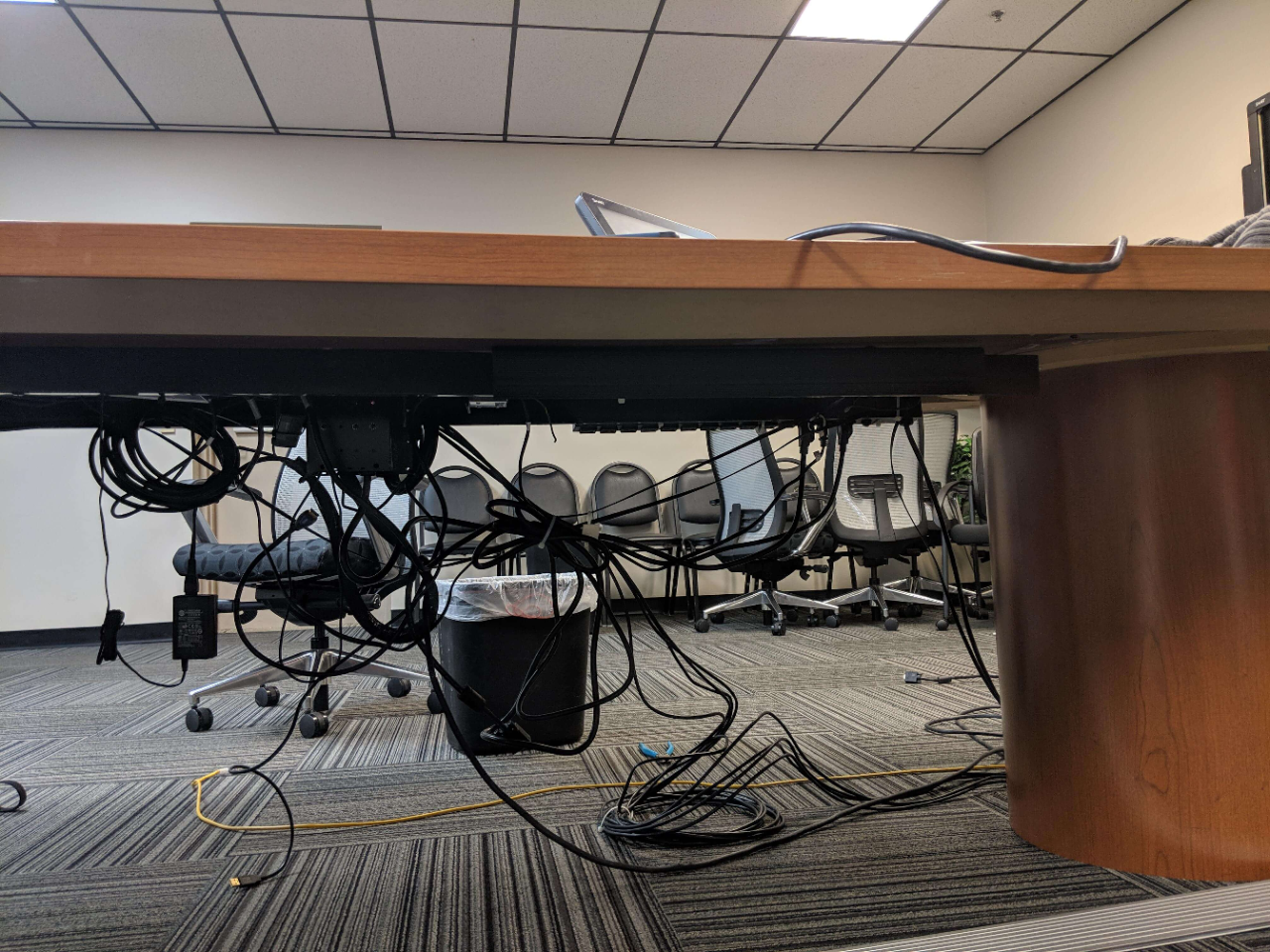 There is a desk full of messing and knotted cables in the meeting room.