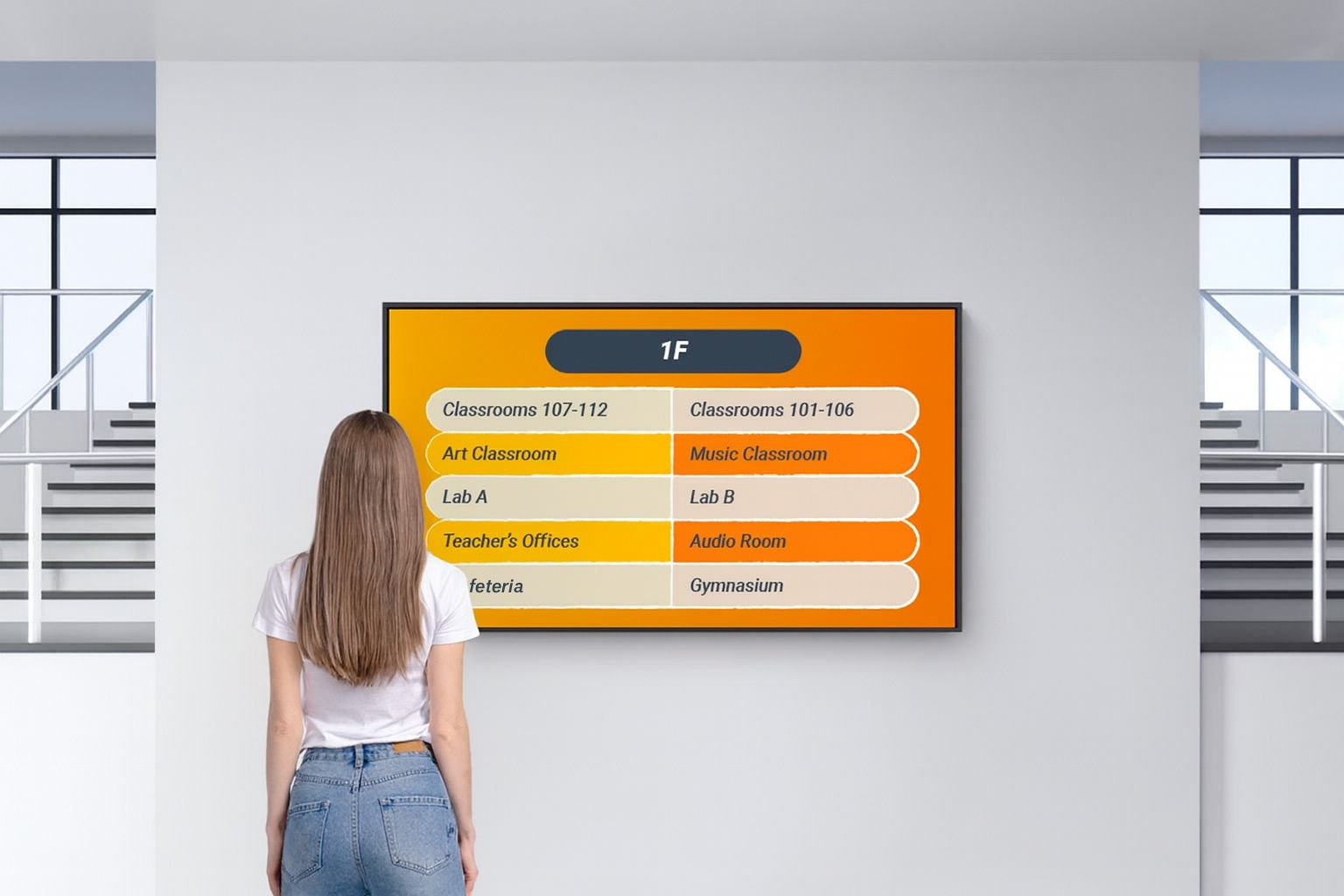 Girl student in the entrance hall looking up where to go on digital signage display